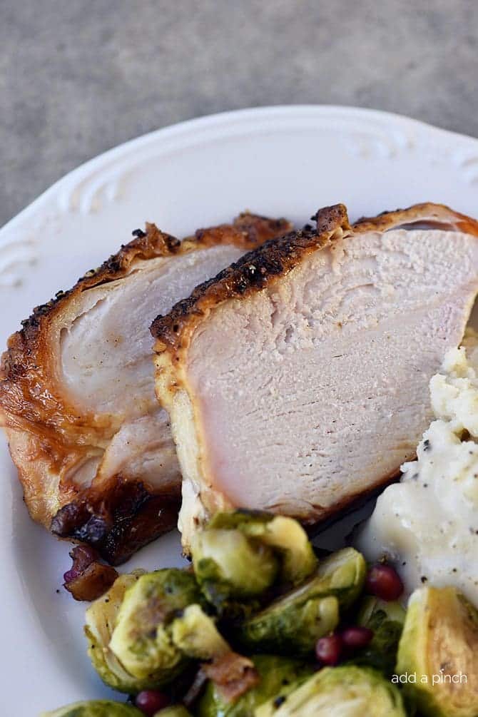 Photo of sliced turkey with brussel sprouts and mashed potatoes on a plate. 
